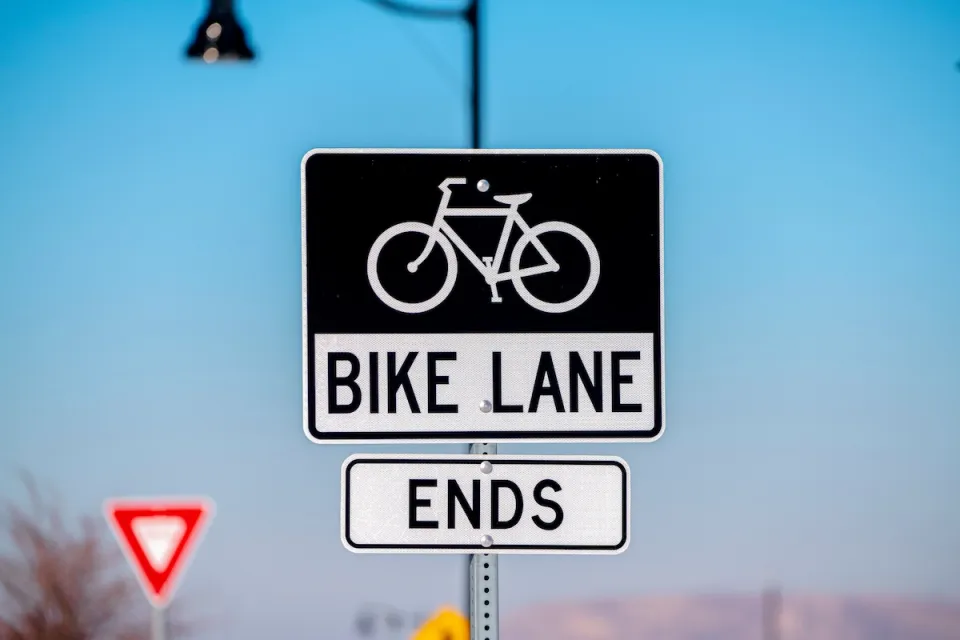 Close-up on black and white "Bike Lane Ends" sign with bike logo.